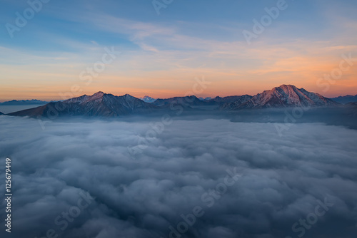 Mountains sprout from low clouds