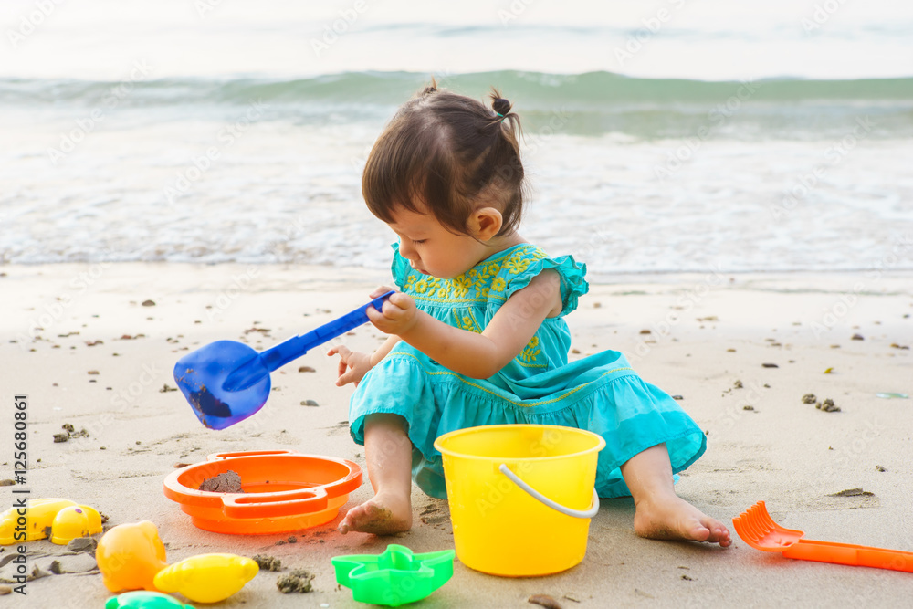 Little girl playing with beach toys during tropical vacation Little girl playing with beach toys during tropical vacation