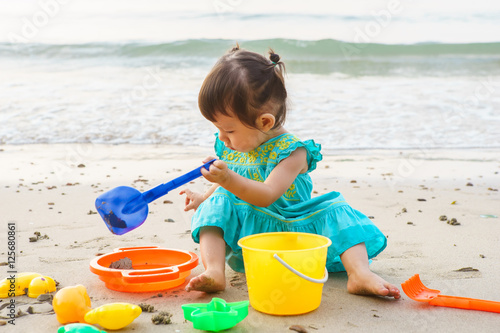 Little girl playing with beach toys during tropical vacation