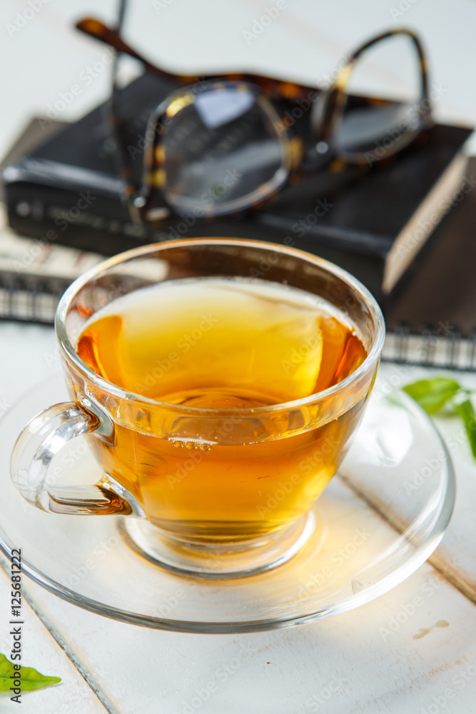 Warm cup of tea and leaves tea on white wooden Warm cup of tea and leaves tea on white wooden
