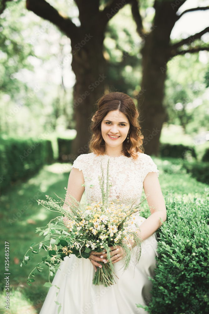 The bride holding bouquet of flowers in park. Wedding The bride holding bouquet of flowers in park. Wedding