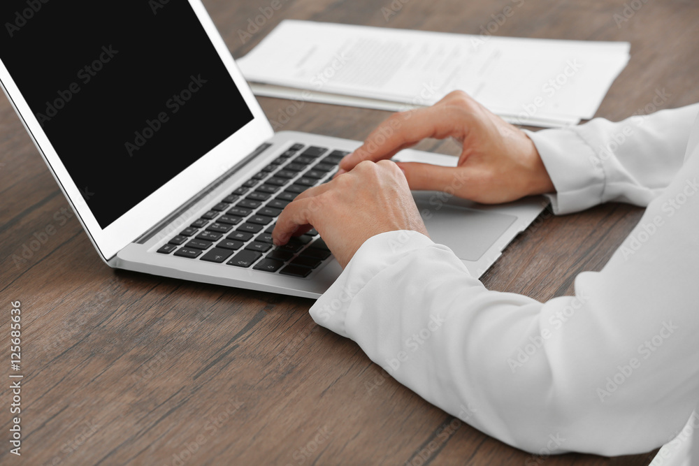 Naklejka premium Successful businesswoman working with laptop in office, close up view