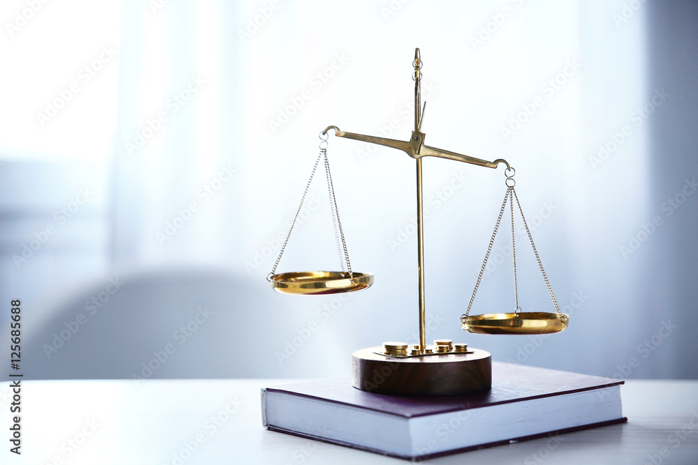 Justice scales and book on table in the room Justice scales and book on table in the room