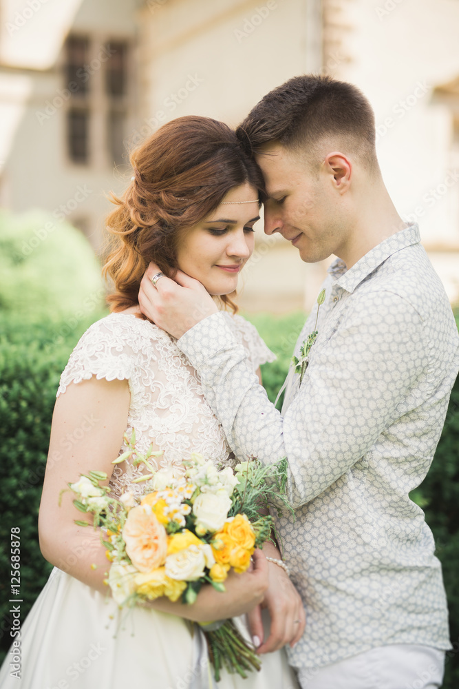 Beautiful fairytale newlywed couple hugging near old medieval castle Beautiful fairytale newlywed couple hugging near old medieval castle