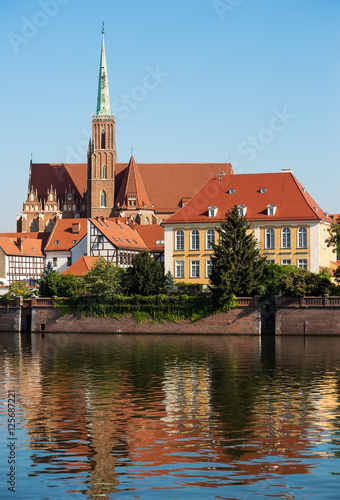 Wroclaw city, view from embankment on odra river and tumski island and catholic Church of the Holy Cross and St. Bartholomew. Famous touristic polish city view