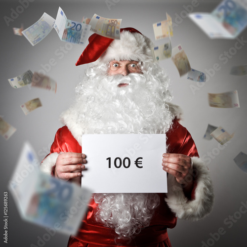 Santa Claus and falling Euro banknotes. One hundred Euro concept
