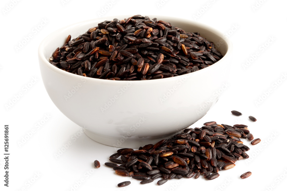 Bowl of Nerone black long grain rice isolated on white. Spilled rice. Bowl of Nerone black long grain rice isolated on white. Spilled rice.