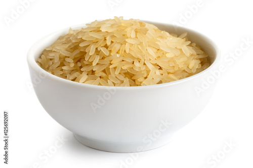 Bowl of long grain parboiled rice isolated on white. photo