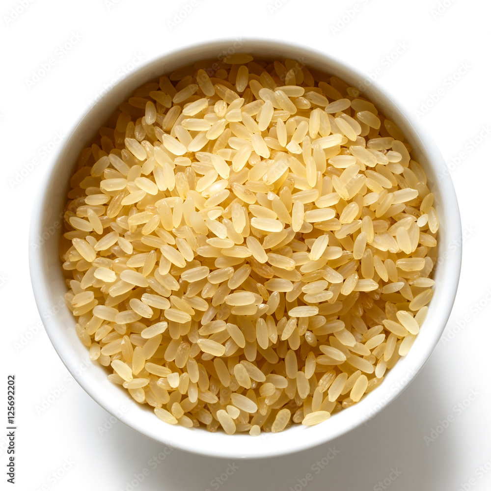 Bowl of short grain parboiled rice isolated on white from above. Bowl of short grain parboiled rice isolated on white from above.