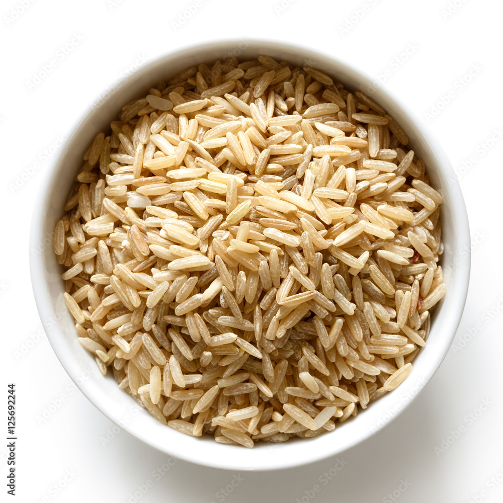 Bowl of long grain brown rice isolated on white from above.