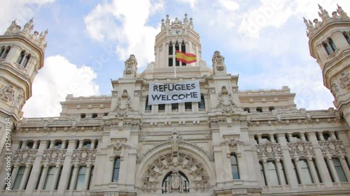 Refugee welcome flag on the facade of Palacio de comunicaciones in Madrid