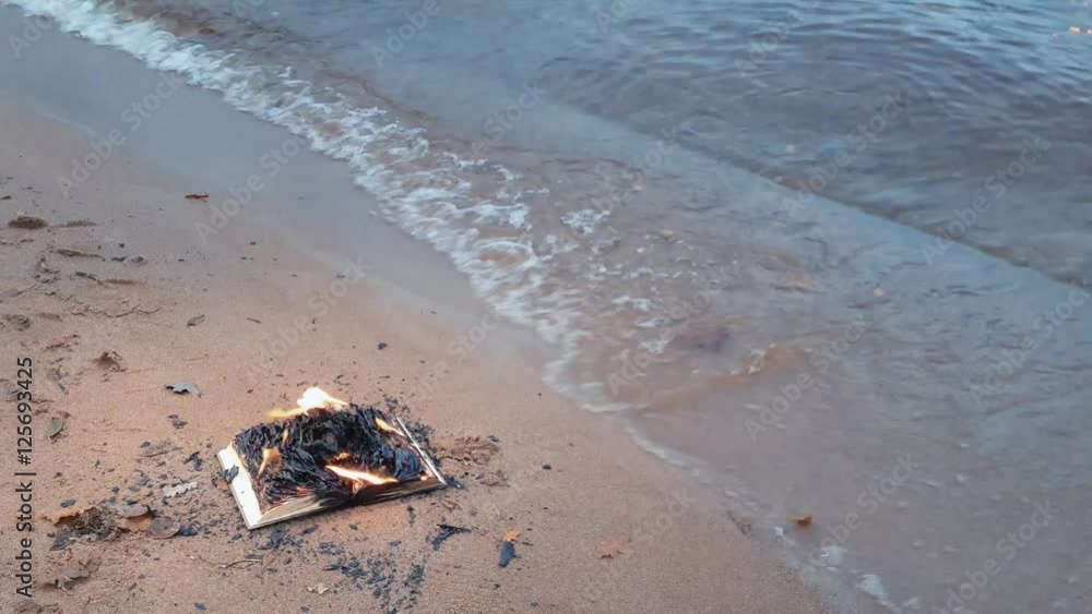 Burning book on the sand at coast Burning book on the sand at coast
