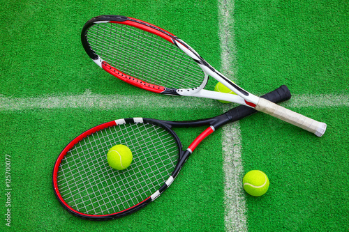 tennis racket with balls on green grass © borisblik