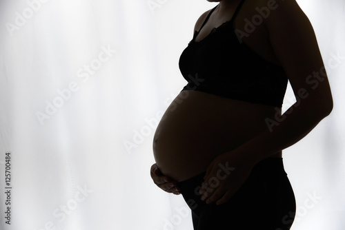 Silhouette of the belly asia pregnant woman with window light