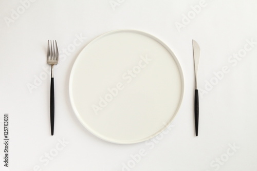 Knife, fork and plate isolated on white background