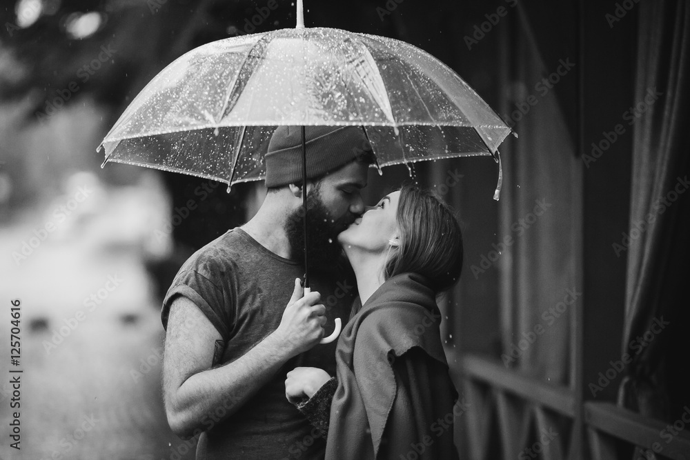 guy and the girl kissing under an umbrella