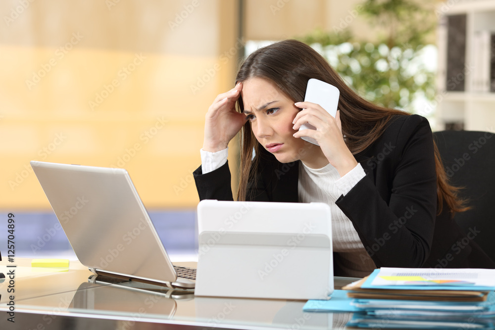 Worried executive with multiple devices Worried executive with multiple devices