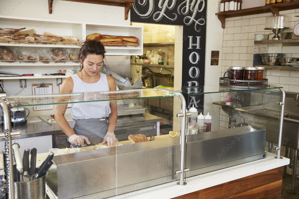 Woman working behind the counter at a sandwich bar Woman working behind the counter at a sandwich bar