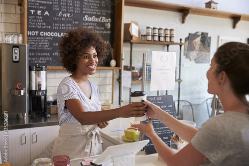 Foto Waitress serving customer over the counter at a coffee shop