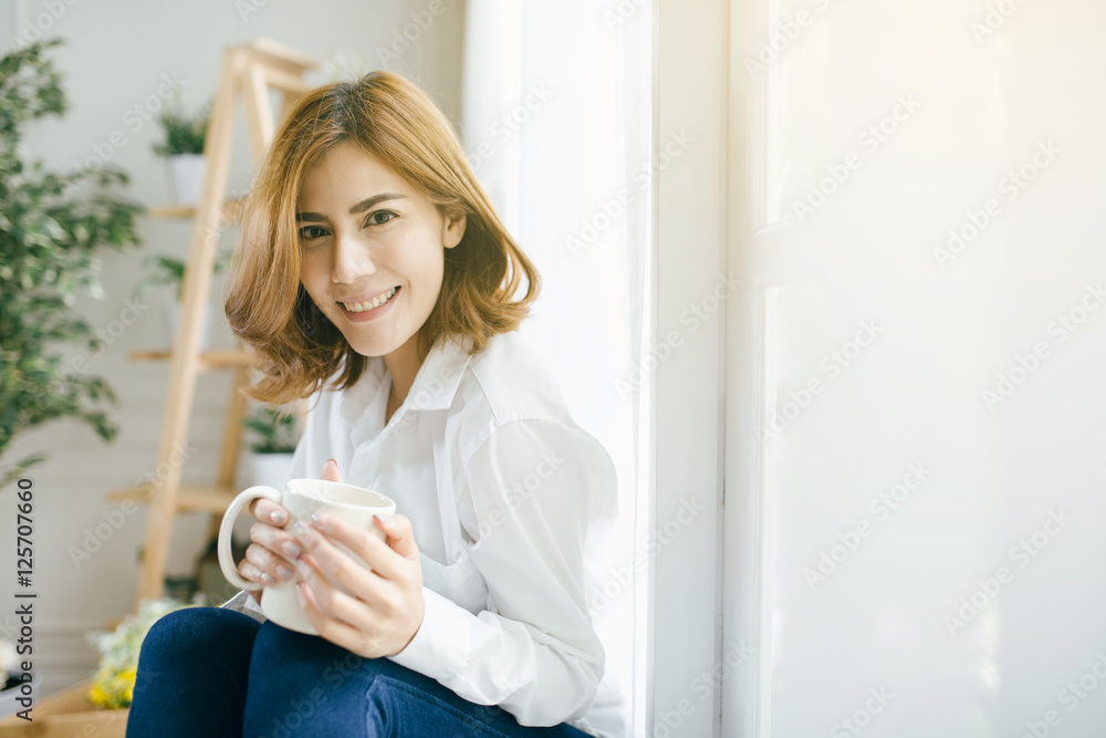 Peaceful Asia woman relaxing at home with cup of tea Peaceful Asia woman relaxing at home with cup of tea