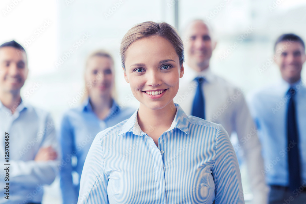 smiling businesswoman with colleagues in office smiling businesswoman with colleagues in office
