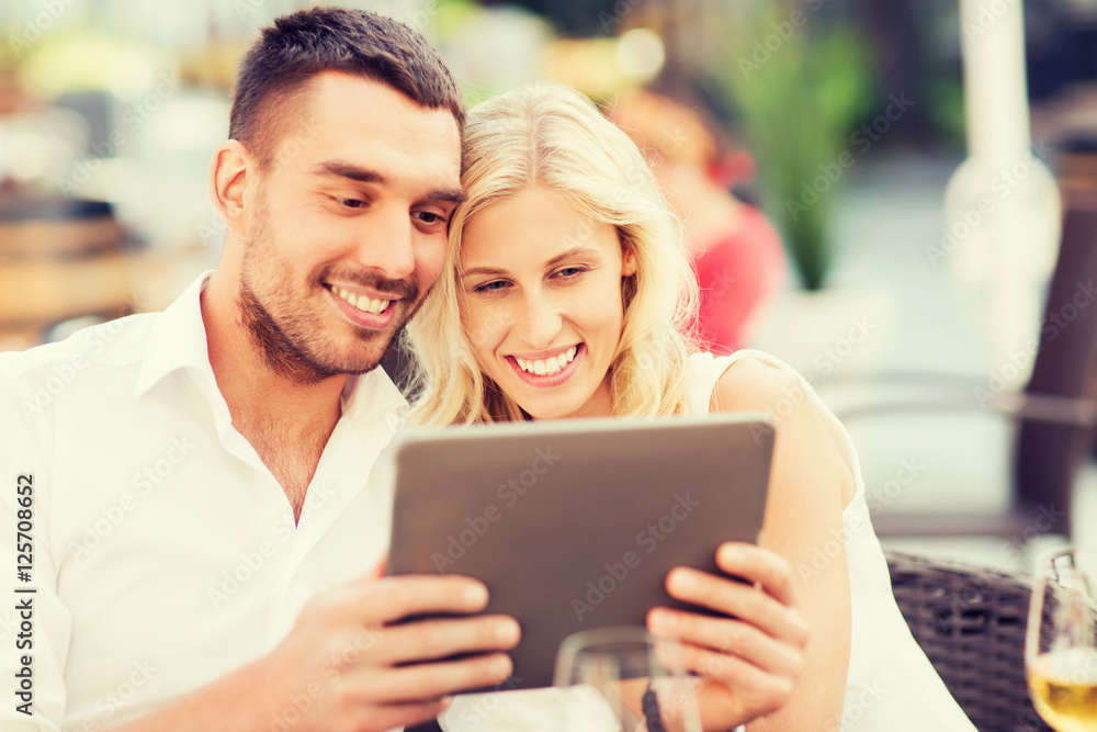 happy couple with tablet pc at restaurant lounge happy couple with tablet pc at restaurant lounge