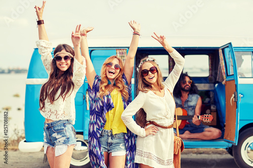 happy hippie friends having fun over minivan car