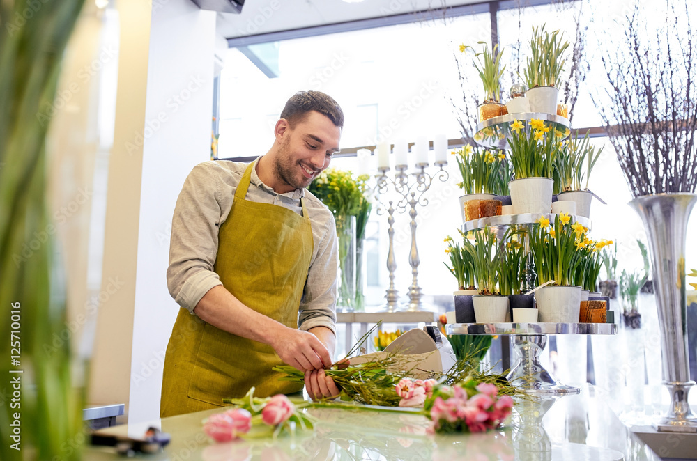 smiling florist man making bunch at flower shop smiling florist man making bunch at flower shop