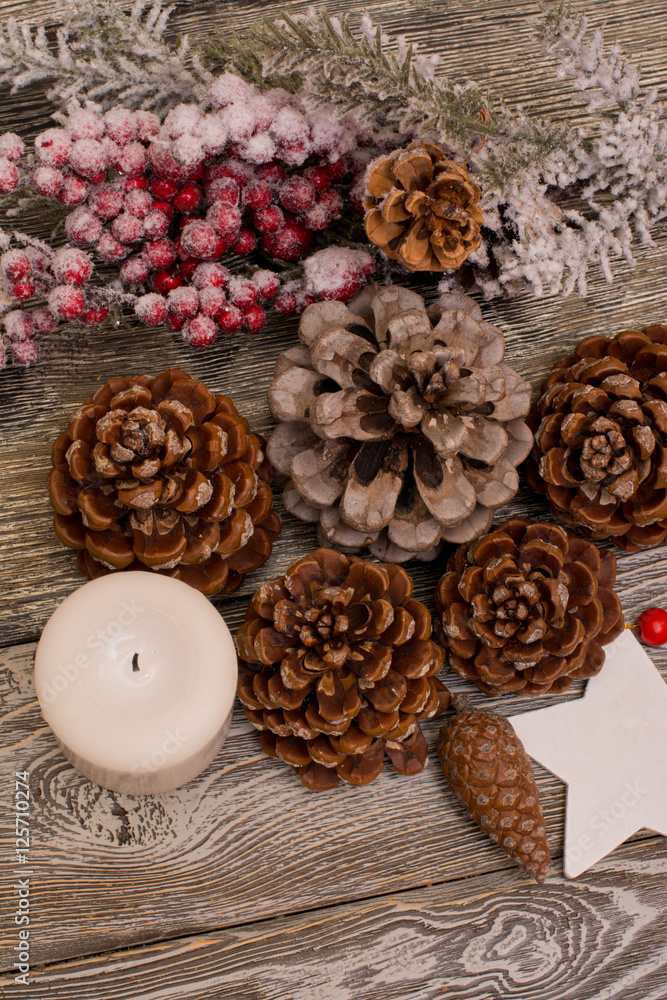 Fir branch in snow, cone, candle, christmas decoration on wooden background Fir branch in snow, cone, candle, christmas decoration on wooden background