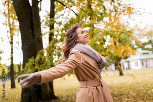 beautiful happy young woman walking in autumn park