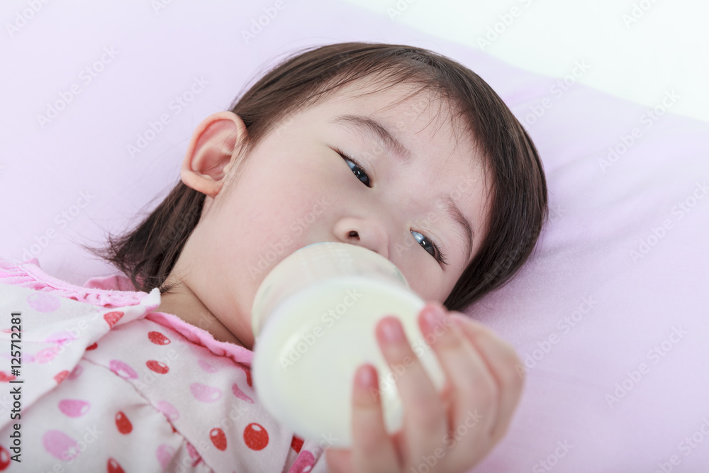 Closeup cute asian girl suck up milk bottle. Drinking milk for good health Closeup cute asian girl suck up milk bottle. Drinking milk for good health