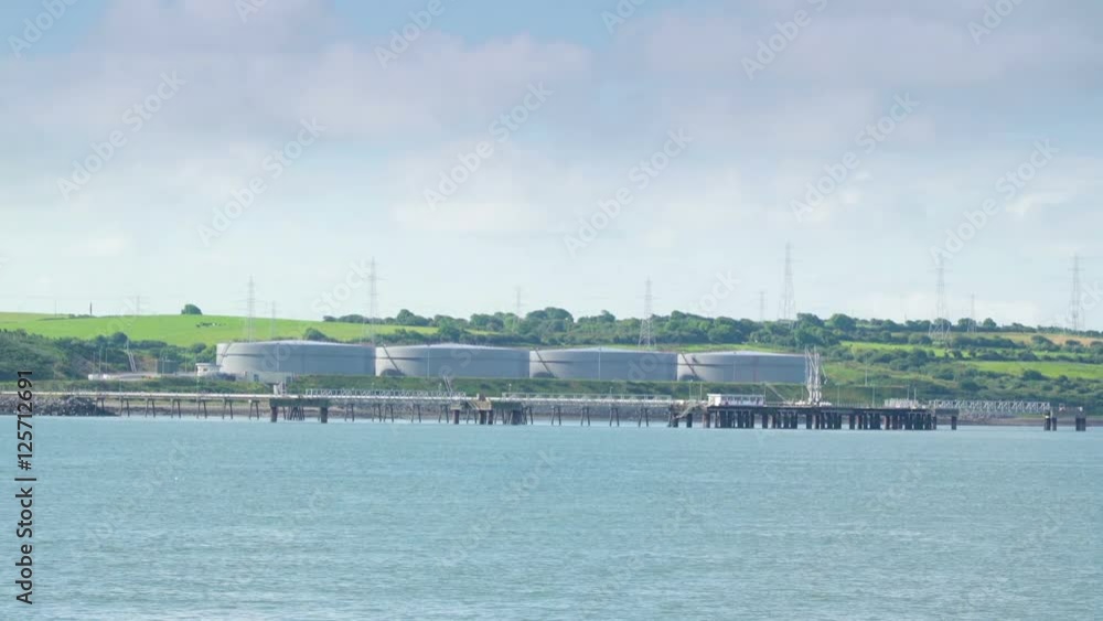 Far away view of the small factory in Killimer Ireland while traveling on the river Far away view of the small factory in Killimer Ireland while traveling on the river