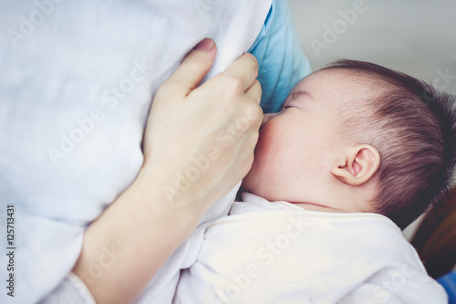 Closeup portrait of mother breastfeeding her newborn baby