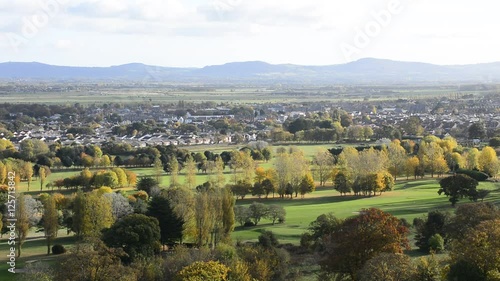 Abergele british village in wales, overlooking the town with mountains on the horizon, showing trees, fields and traffic from a high distant vantage point. photo