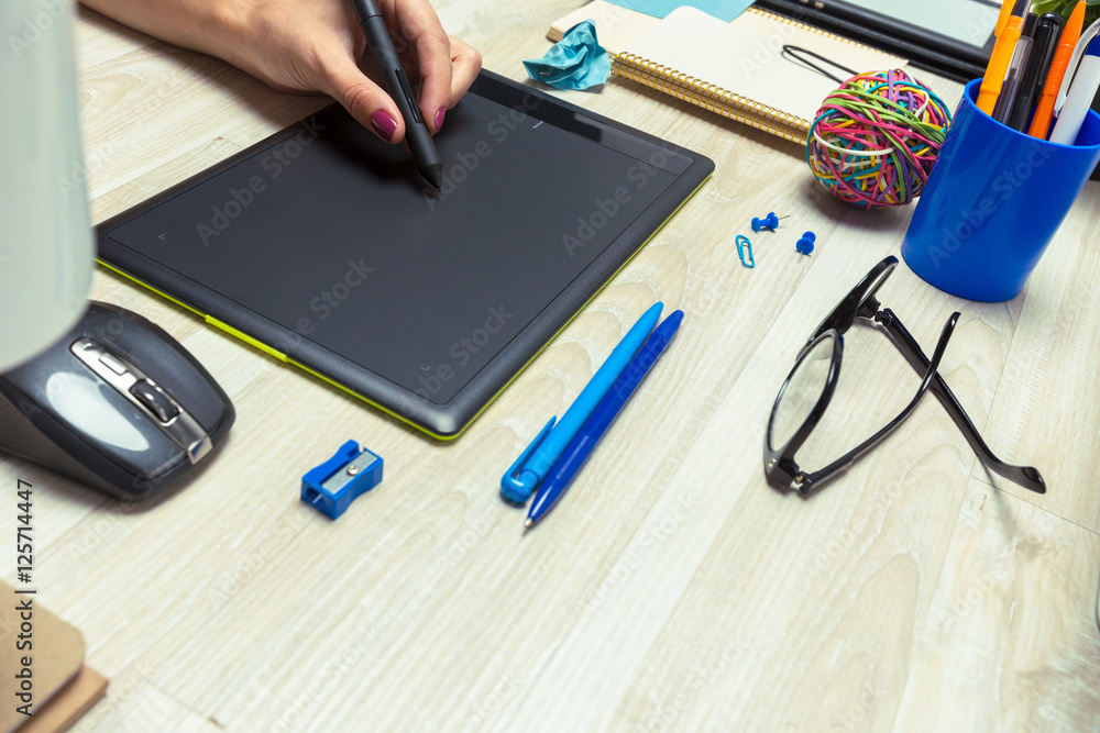 Hand of graphic designer working with stilus and tablet Hand of graphic designer working with stilus and tablet