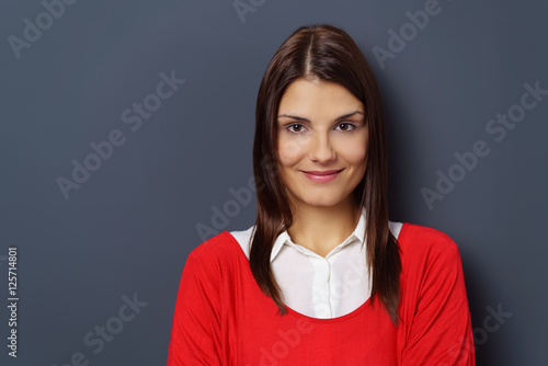 frau mit langen braunen haaren vor grauer wand photo