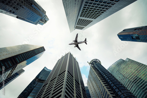 Photography Singapore city buildings and a plane flying overhead in morning