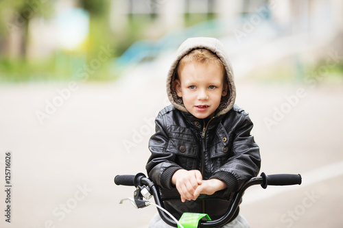 portrait of adorable little urban boy wearing black leather jack