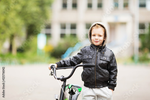portrait of adorable little urban boy wearing black leather jack
