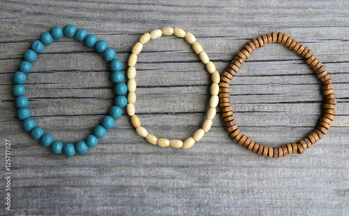 Colorful wooden bracelets on old wooden background.Handcrafted bangles.Handmade wooden bead bracelet.Selective focus.Copy space.