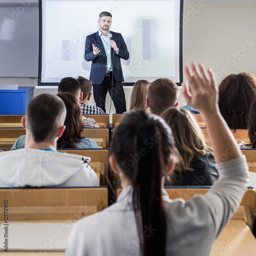 Student raising hand during seminar