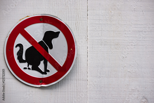 Cartel prohibido permitir que las mascotas hagan sus necesidades  sobre vieja puerta de madera con espacio para texto blanca photo
