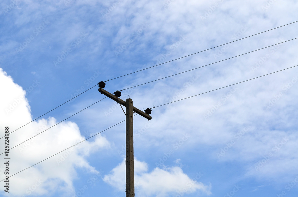 Electrical pole with power lines against hazy blue sky Electrical pole with power lines against hazy blue sky
