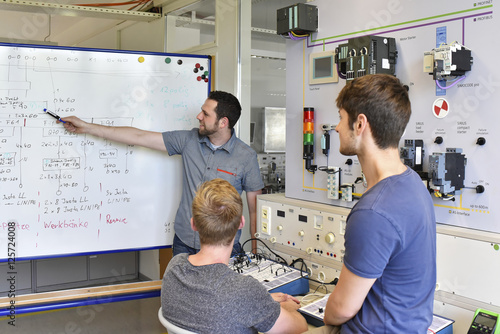 Students looking at technical instructor at whiteboard