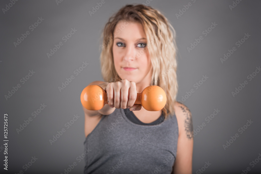 Woman holding weight, selective focus on weight Woman holding weight, selective focus on weight