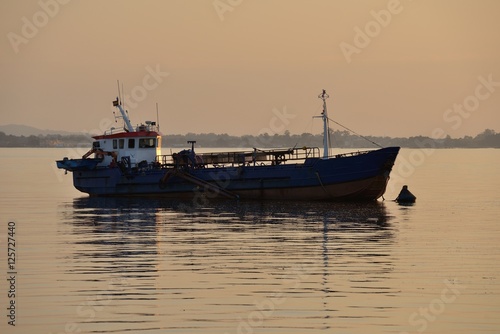 fishing boat anchored at sunset