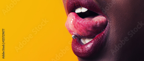 Photo African girl tongue stuck out showing piercing letterbox