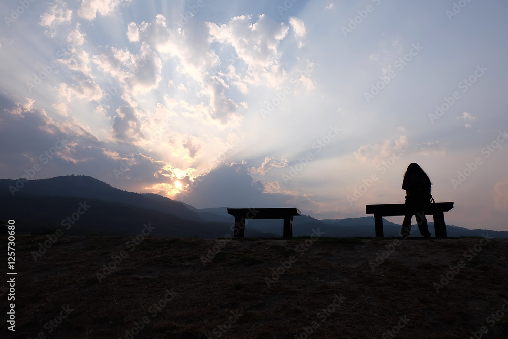 Silhouette of single adult woman watching warm sunset. Silhouette of single adult woman watching warm sunset.