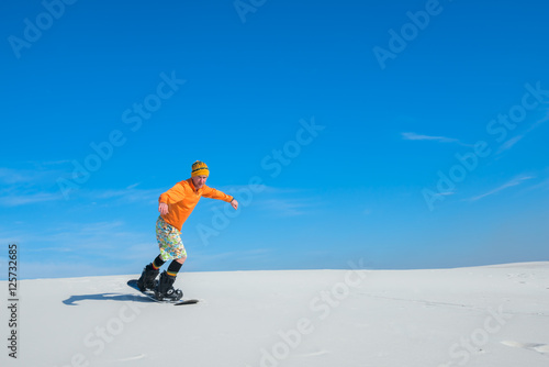 Sand boarder slides down the slope