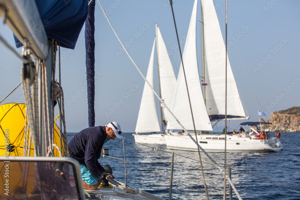 Man skipper on the sailing boat during yacht regatta on the Sea. Man skipper on the sailing boat during yacht regatta on the Sea.